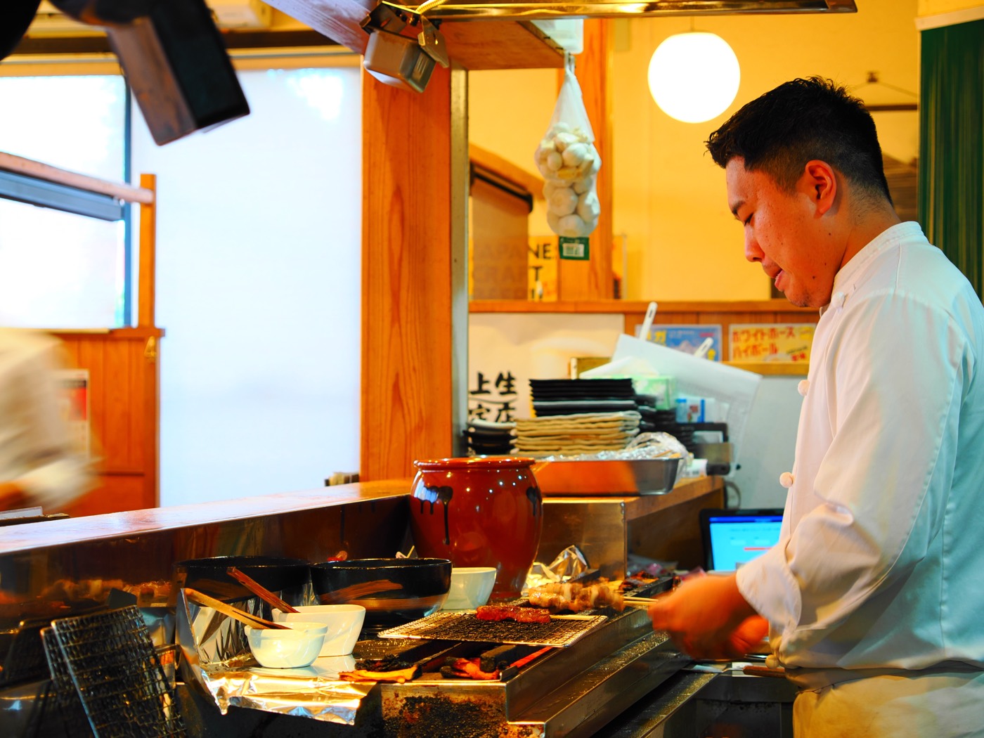 炭火の前に立つ焼き手